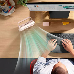 Usb Cooling Fan - Top-down view of a white small fan blowing air toward hands typing on a keyboard