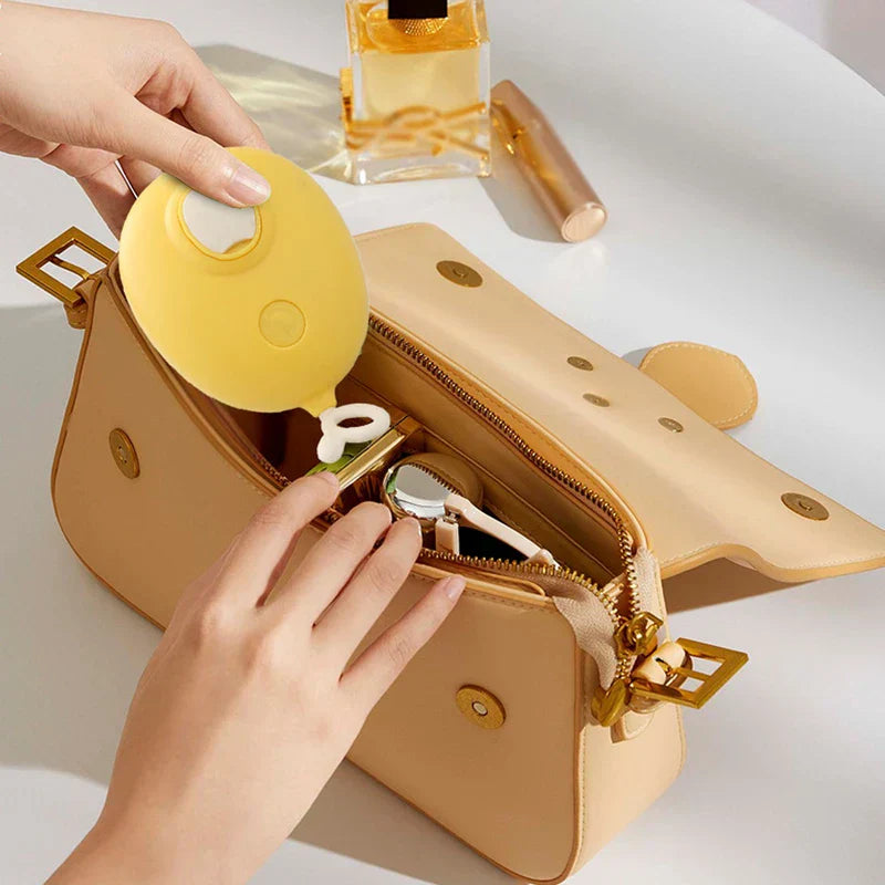 Uv Light Pet Grooming Comb - Hand placing a yellow oval silicone item into an open tan leather handbag