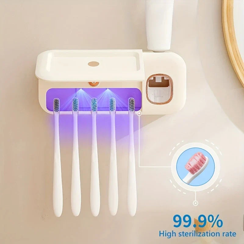Uv Toothbrush Sterilizer - Wall-mounted unit holding five toothbrushes under purple UV light, with attached toothpaste dispenser and 99.9% sterilization rate label.