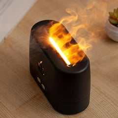Top view of black ultrasonic aroma diffuser with glowing simulated flame and mist, on a wooden table near a small potted succulent