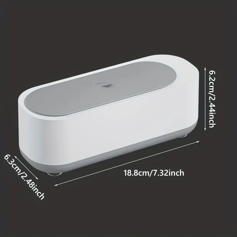 Dimensioned front view of a white and gray eyeglass cleaner machine on black background