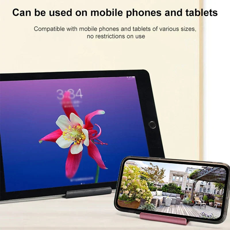 Cell Phone Holder - Two small device stands holding a black tablet and a smartphone upright on a light table surface