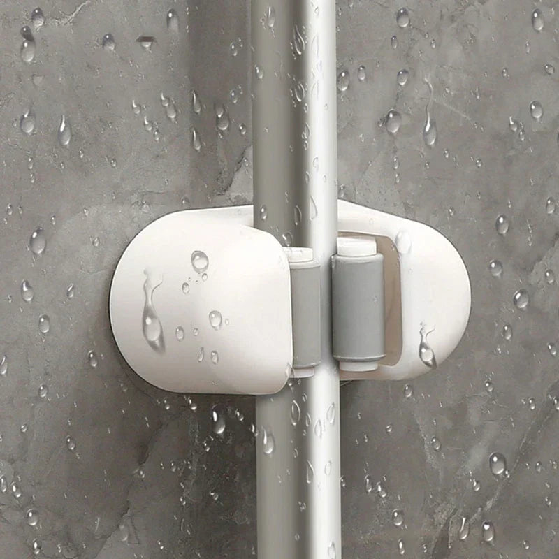 Utility Tool Storage Gripper Hanger System - Close-up of holder gripping a tool handle, covered in water droplets on wet tile