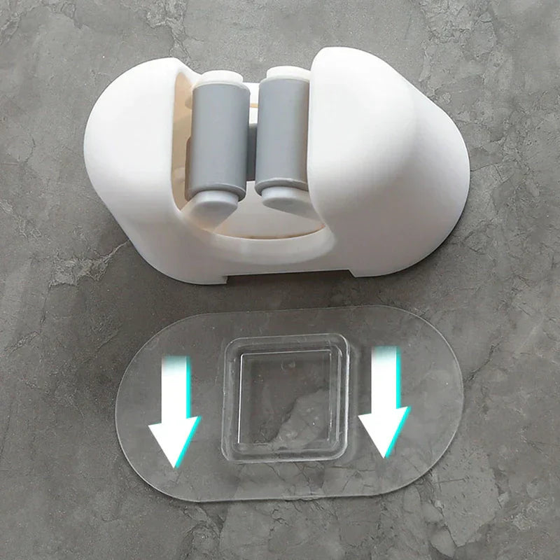 Utility Tool Storage Gripper Hanger System - White mop holder separated from its clear adhesive mounting pad on a gray textured surface, arrows point down on the pad