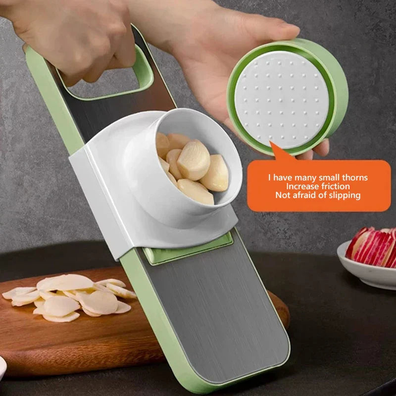 Mandoline - A person slices garlic using the slicer with the hand guard; inset shows textured hand guard grip surface