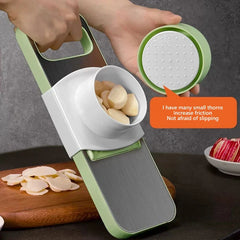 Mandoline - A person slices garlic using the slicer with the hand guard; inset shows textured hand guard grip surface