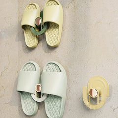 Slipper Rack Organizer - Two installed units holding pairs of slide slippers on a textured light wall, with one empty unit visible