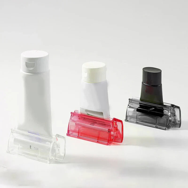 Wall Mount Toothpaste Dispenser - Three tube squeezers in clear, red and smoky gray, each holding a different cosmetic tube, against a white background
