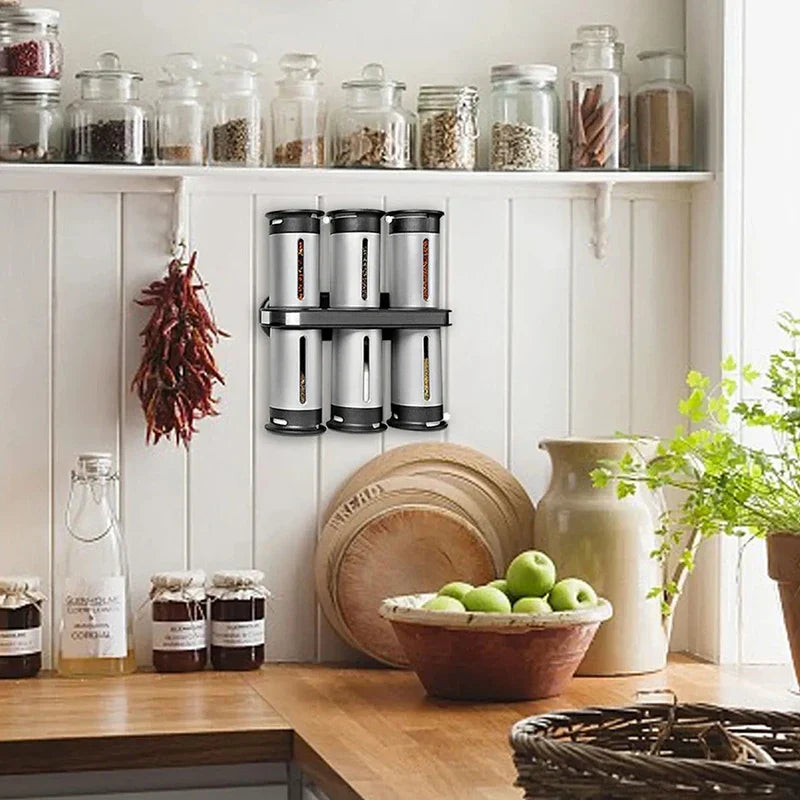 Magnetic Spice Rack Shelf - Spice rack mounted on a white paneled kitchen wall above a wooden countertop, surrounded by kitchenware and produce.