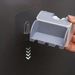 Mop And Broom Holder - Hand holding a gray wall holder, aligning it to a clear adhesive wall hook with downward arrows indicating sliding installation