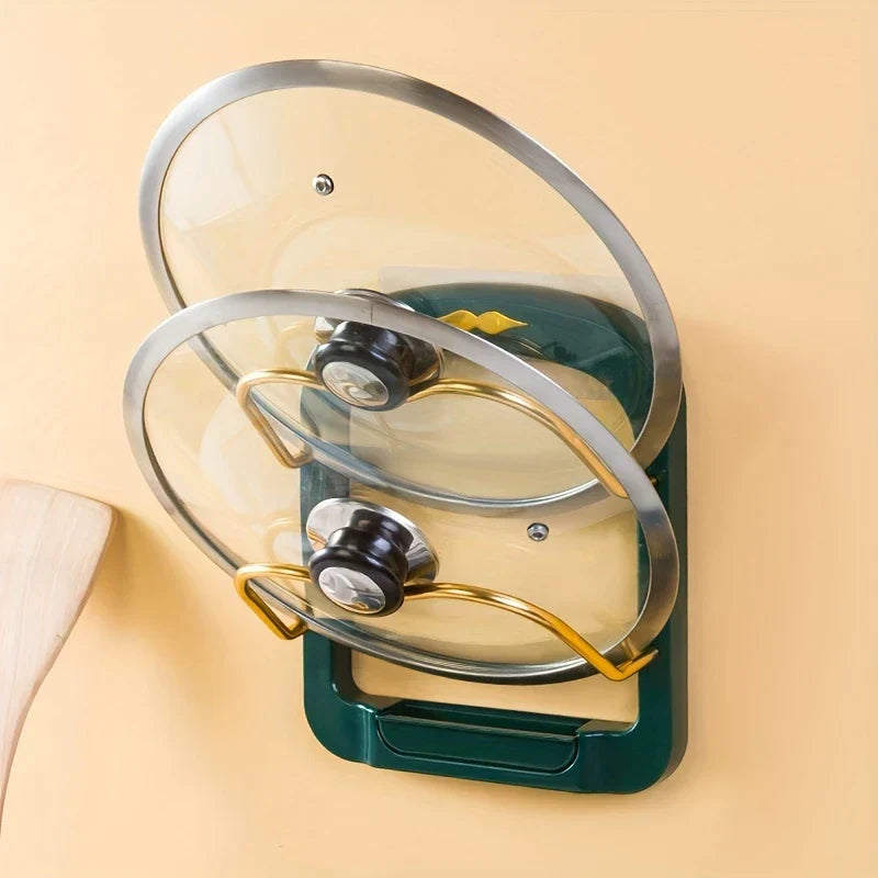 Pot Lid Organizer - Green wall-mounted lid rack holding two glass lids, partial wooden spoon on light peach background