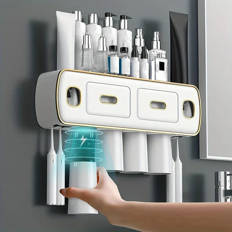 White wall mount toothbrush holder toothpaste dispenser set with toiletries on top, toothbrushes, and cups below.