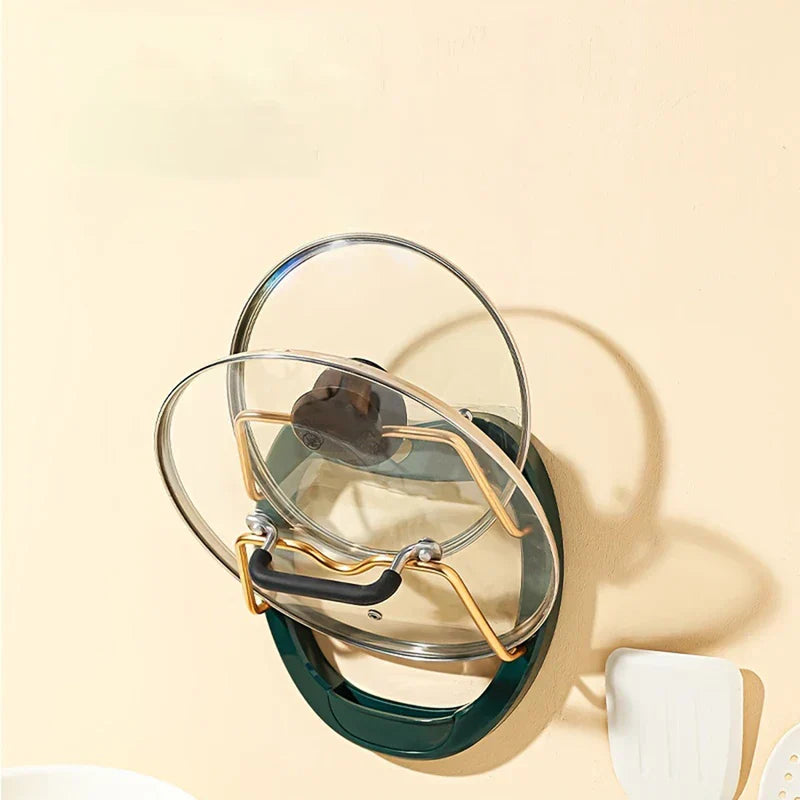 Wall Mounted Pot Lid Holder - Dark green wall-mounted lid holder holding two glass lids, with white kitchen utensils partially visible beside it on a light wall.
