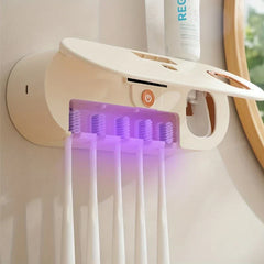 Uv Toothbrush Sanitizer - Cream-colored wall-mounted oral care device with open cover holding five manual toothbrushes under purple sanitizing light