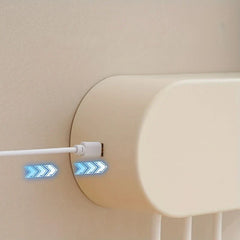 Uv Toothbrush Sanitizer - Side view of the dispenser with a white USB charging cable plugged into its port