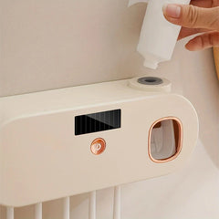 Uv Toothbrush Sanitizer - Close-up of wall-mounted toothbrush holder top, hand placing a toothpaste bottle into the dispenser port