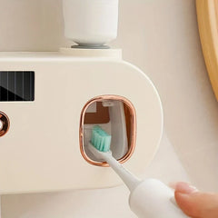 Uv Toothbrush Sanitizer - A hand holds an electric toothbrush inserted into a rose gold-trimmed opening on a wall-mounted bathroom organizer.