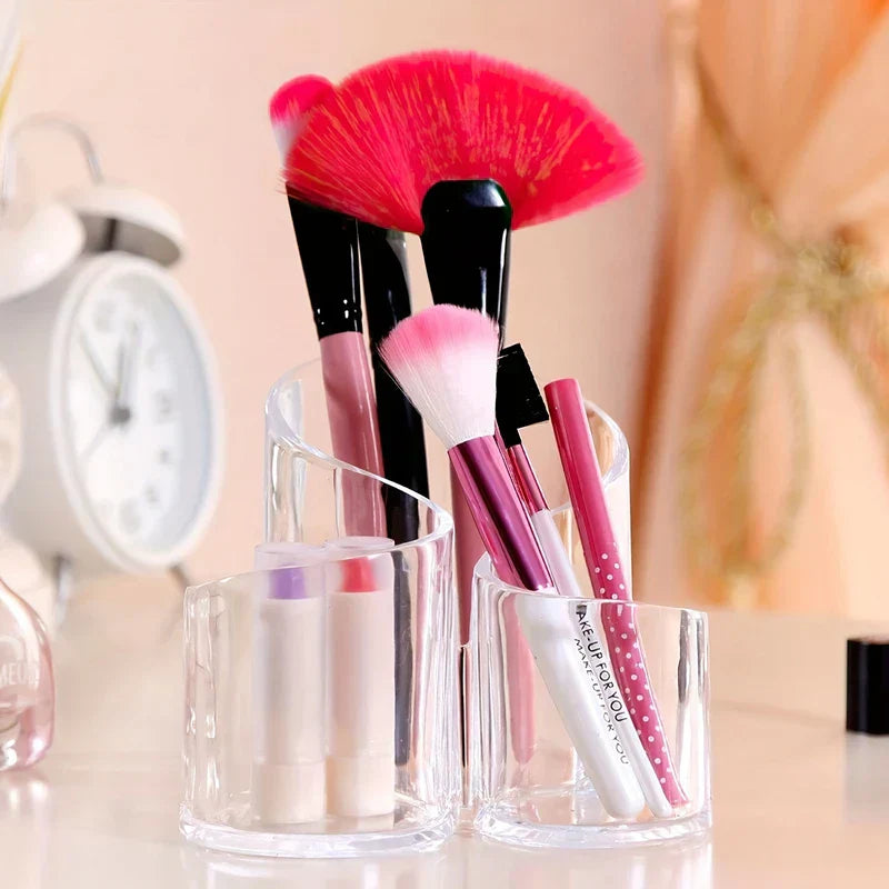 kosmetikständer - Transparenter Kosmetikständer aus Kunststoff, der Make-up-Pinsel und Lippenprodukte auf einer Kosmetikfläche hält, mit Wecker im unscharfen Hintergrund