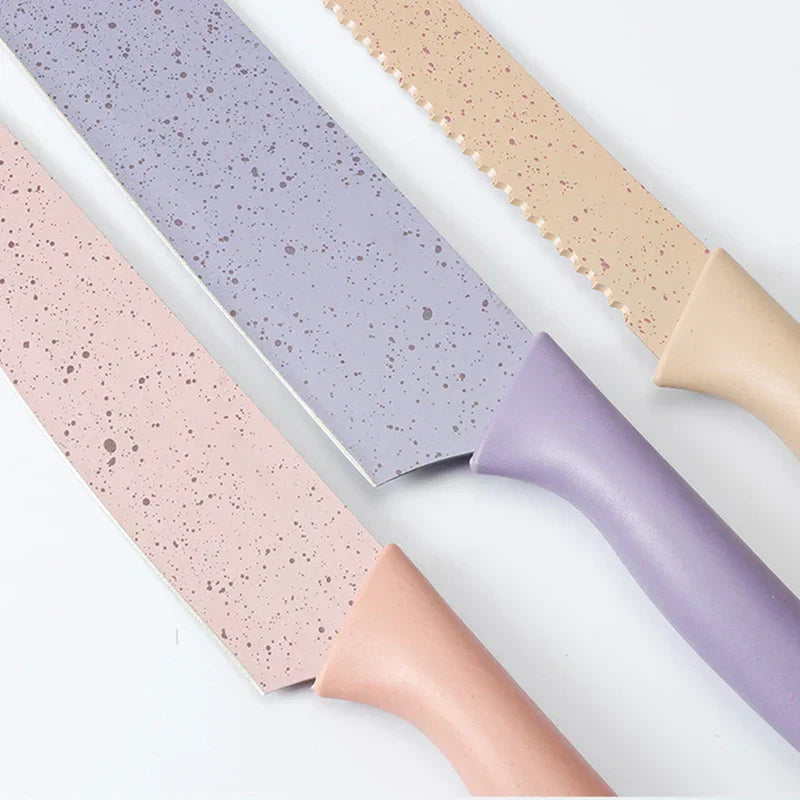 Organizer Box - Overhead view of three speckled kitchen knives with pink, purple, and beige handles laid on a white surface