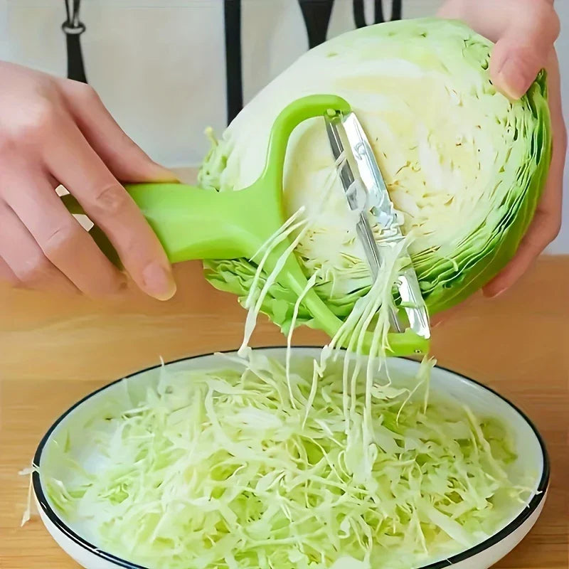 Vegetable Slicer - Green handled tool shredding green cabbage into thin strips over a bowl