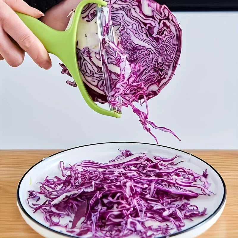 Vegetable Slicer - Green handled tool shredding purple cabbage into thin strips over a plate