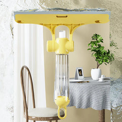 Herramienta limpiadora de ventanas: mini trapeador amarillo y transparente presionado contra vidrio mojado, con escena reflejada del comedor visible a través del vidrio