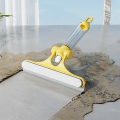 Herramienta limpiadora de ventanas: herramienta de limpieza manual amarilla con hoja blanca descansando sobre superficie de baldosas mojadas junto a baldosa seca, mango transparente con lazo para colgar