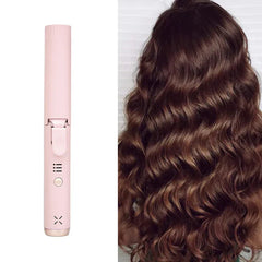 Pink hair curler next to long wavy brown hair, showing curling result