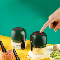 Garlic Mincer - Finger pressing the top power button of a cordless chopper next to prepared minced ingredients and fresh produce