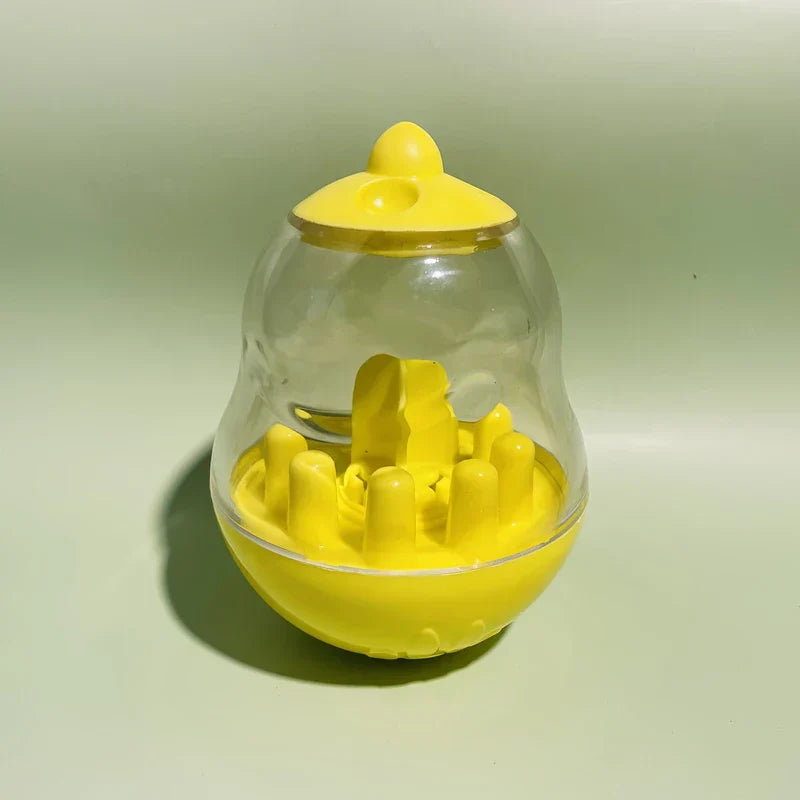 Interactive Pet Toy - Yellow and clear plastic tumbler-shaped pet treat dispenser toy on a light green surface