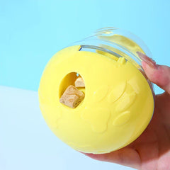 Interactive Pet Toy - Hand holding a yellow treat-dispensing toy showing a treat protruding from its side opening