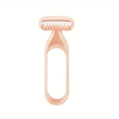 مزيل الشعر - شفرة حلاقة يدوية بلون خوخي فاتح على شكل حرف T مع مشط حماية واقٍ فوق الشفرة ومقبض بحلقة مفرغة، على خلفية بيضاء سادة