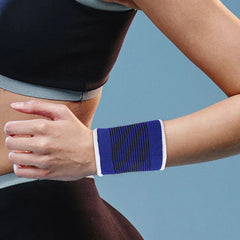 Wrist Brace - Blue striped knit wrist sleeve worn on a person’s wrist, with the person’s hand and partial workout attire visible.