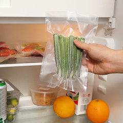 Mini Bag - Hand holding a vacuum-sealed bag of okra inside an open refrigerator