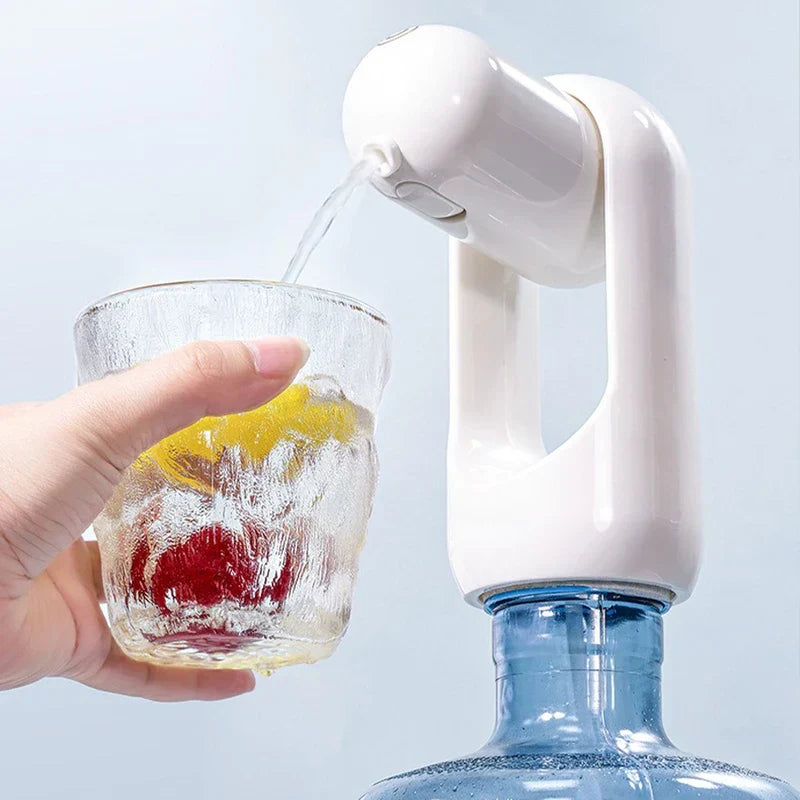 A hand holds a glass with fruit under a white water pump attached to a blue water bottle, dispensing water into the glass.