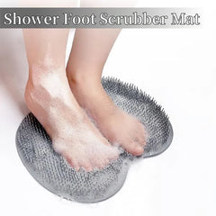 Feet covered in soap suds standing on a foamy silicone shower foot scrubber mat in a shower setting