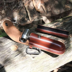 Bushcraft Hand Auger Wrench - Open brown leather drill sheath with silver auger drill part, D-ring carabiner, and drill sleeve on weathered wood surface