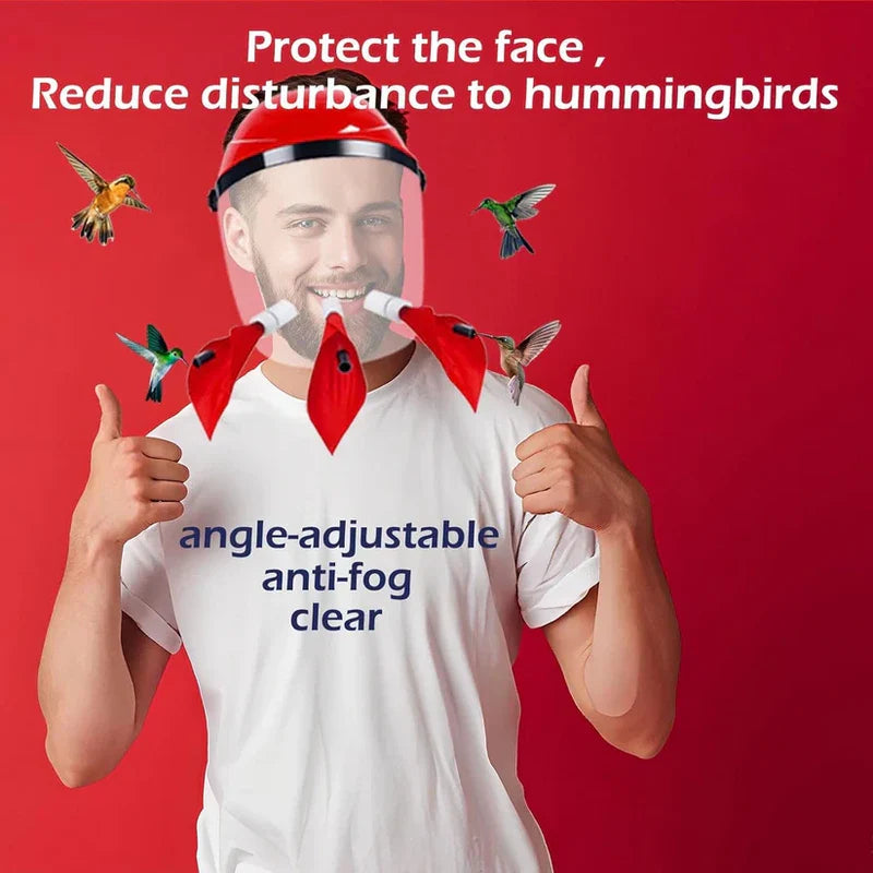 Hummingbird Feeder Helmet - Man wearing a red head-mounted clear face shield with three attached red flower ports, giving two thumbs up; hummingbirds are near the ports against a red background.