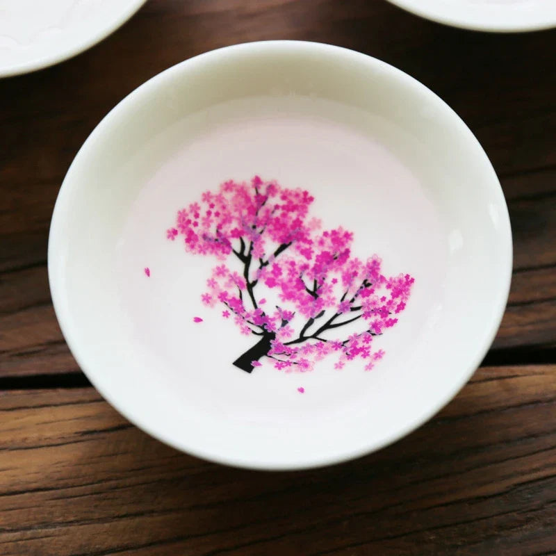 Sakura Sake Cup - White ceramic cup interior with fully visible bright pink cherry blossom tree design with falling petals