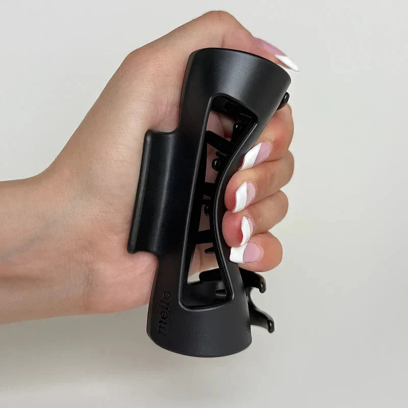 Cloud Clip - Hand with pink and white manicure squeezing an open black matte hair claw clip