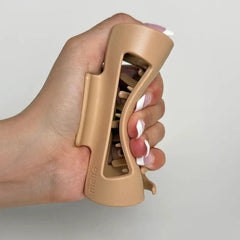 Cloud Clip - Hand with pink and white manicure squeezing an open beige matte hair claw clip