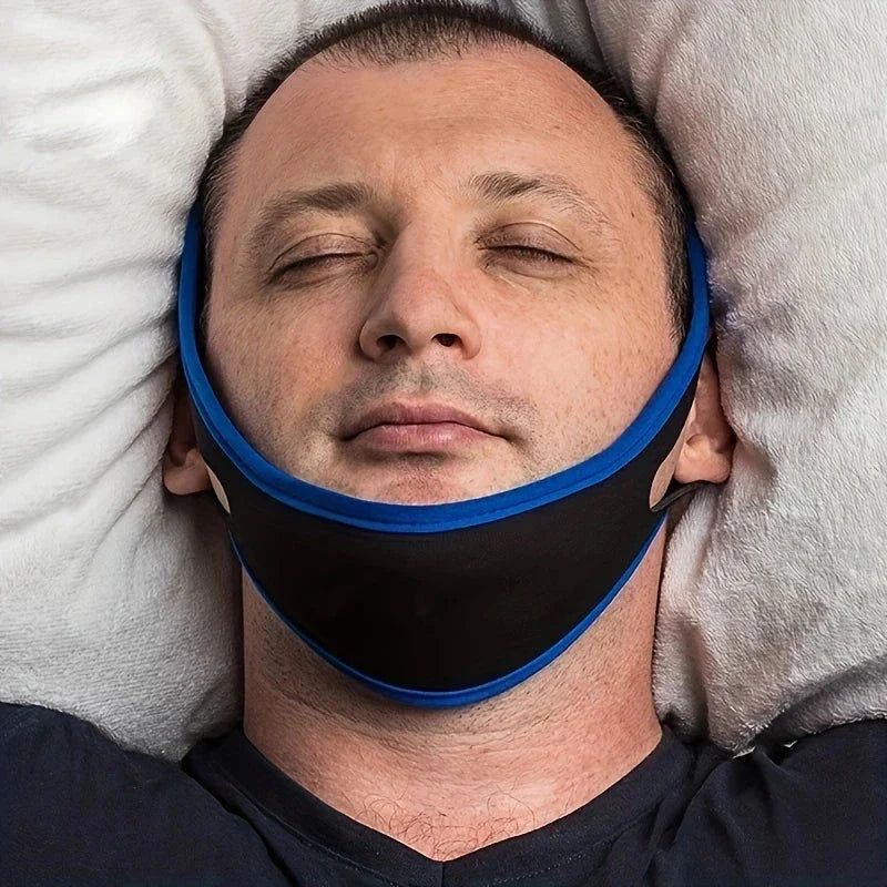 رجل مستلقٍ على وسائد وعيناه مغمضتان، ويرتدي حزام ذقن باللونين الأسود والأزرق حول فكه