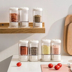 Set of clear spice jars with different seasonings on kitchen shelf