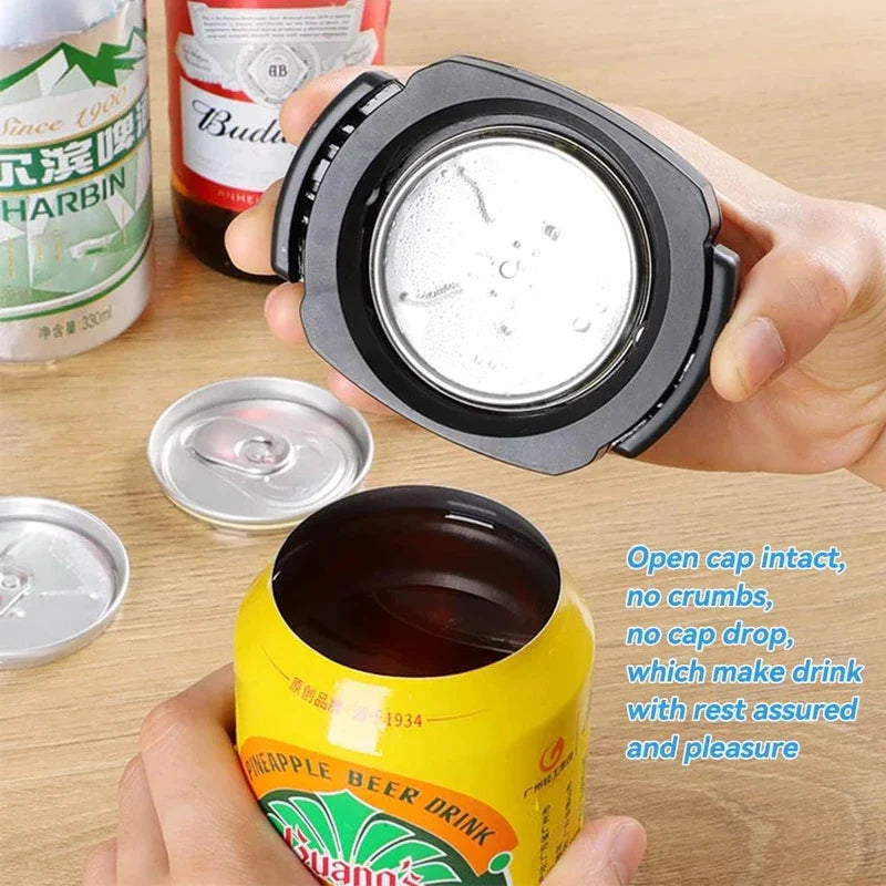 Manual Can Opener - A hand holds a black can opener above an opened yellow drink can, with removed silver can tops on a wooden surface.
