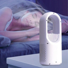 Tower Fan - Side view of white bladeless tower device with vent grilles, resting on a white bedside table with a sleeping person in the background