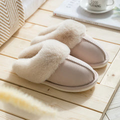 Zapatilla - Zapatilla de casa tipo slip-on en beige claro con collarín de piel sintética crema y esponjosa, exhibida sobre piso de madera clara