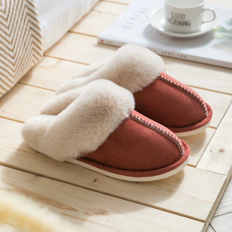 Zapatilla - Zapatillas tipo mule en rojo óxido con ribete de piel esponjosa, exhibidas sobre piso de madera clara