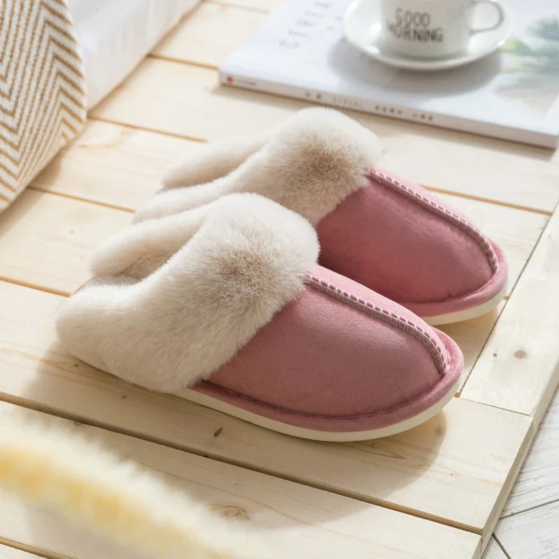 Zapatilla - Zapatilla de casa tipo slip-on en rosa empolvado con collarín de piel sintética crema y esponjosa, exhibida sobre piso de madera clara