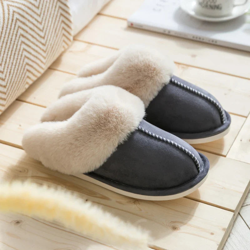 Zapatilla - Zapatillas tipo mule en gris oscuro con ribete de piel esponjosa, exhibidas sobre piso de madera clara