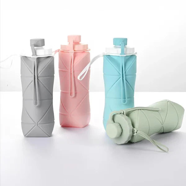 Botella de agua plegable de silicona: cuatro botellas de agua plegables de silicona en gris, rosa, azul y verde: tres en posición vertical, una verde claro yace plegada sobre una superficie blanca